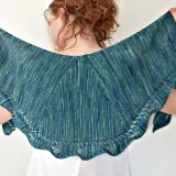 Frau hält ein wunderschönes, blau-grün meliertes **Tuch stricken** mit zarten Lochmustern am Rand.