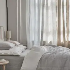 Schlafzimmer mit Bett, Kissen und Vorhängen. Kreative Gardinen Ideen für ein gemütliches Ambiente.