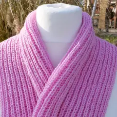 Ein rosa gestrickter Schal mit einem einfachen Rippenmuster, perfekt für Anfänger.