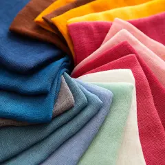 Stoffbahnen in verschiedenen Farben, von Blau über Grün bis Rosa und Braun, zeigen die Vielfalt beim polyester färben.