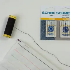 Schwarzer faden zum reparieren von kleidung, Nadeln und Stoff mit bunten Stichproben.