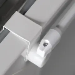 Detailaufnahme einer weißen Gardinenstange, die nur an den Seiten befestigt ist. Ein Teil der Halterung ist sichtbar.