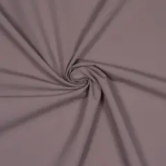 Ein glatter, taupefarbener Stoff, der sich zu einer Spirale dreht. Dies ist ein Beispiel für Popeline, ein dicht gewebtes Baumwollmaterial.