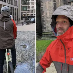 Mann mit Helm auf Fahrrad, trägt eine zweifarbige Funktionsjacke. Nahaufnahme des Mannes in der Jacke mit Kapuze.
