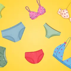 Bunte Unterwäsche aus Elasthan-Stoff, darunter Slips und BHs mit Herz- und Tupfenmuster, auf gelbem Hintergrund.