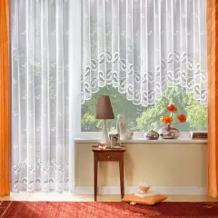 Orange und weiße Gardinen formen ein gemütliches Fensterbild. Zarte Muster zieren die weißen Stoffe, während die orangefarbenen Vorhänge Wärme ausstrahlen.