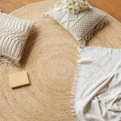 Runder Jute-Teppich mit Kissen und Decke. Jute ist ein Naturmaterial, das für seine Strapazierfähigkeit und seinen rustikalen Charme bekannt ist.
