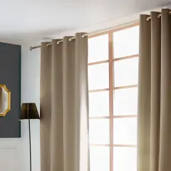 Ein Vorhang wird an einer Stange über einem Fenster angebracht. Daneben ein Spiegel und eine Lampe.