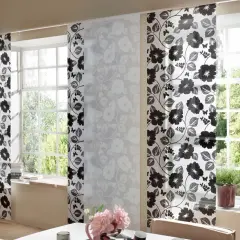 Schiebegardine kurz mit floralem Muster in Schwarz und Weiß. Helle Paneele mit zarten Blüten und dunklere mit kräftigen Blumen und Schmetterlingen schmücken das Fenster.
