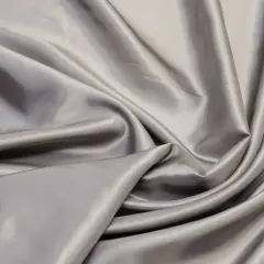 Glänzender, grauer Stoff mit Falten. Viskose Nachteile: knittert leicht, empfindlich bei Nässe.