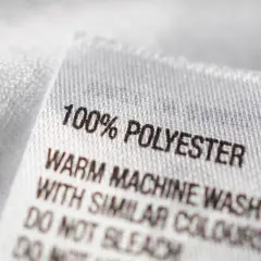 Etikett zeigt: 100% Polyester. Maschinenwäsche warm mit ähnlichen Farben. Nicht bleichen.