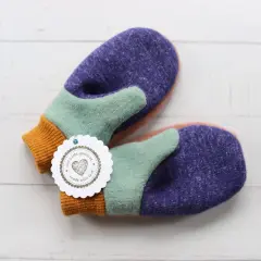 Bunte Fäustlinge mit einem "mit Liebe gemacht"-Anhänger. Ideal für DIY-Projekte, hier gibt es handschuhe schnittmuster kostenlos.