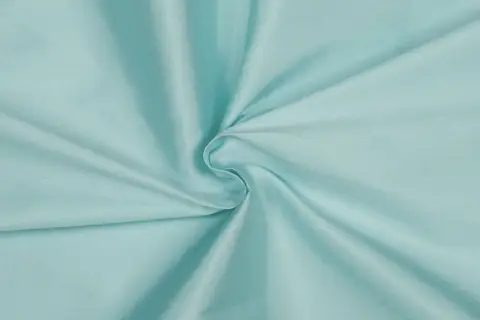 Türkis schimmerndes Gewebe, das an Kunstseide erinnert. Die Chemiefaser fällt weich und glatt.