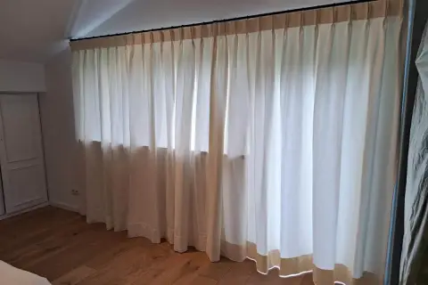 Helle Gardinen mit Faltenwurf, verschiedene Varianten der Aufhängung und des Stoffes, die ein gemütliches Ambiente schaffen.