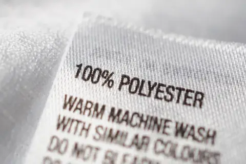 Etikett zeigt: 100% Polyester. Maschinenwäsche warm mit ähnlichen Farben. Nicht bleichen.