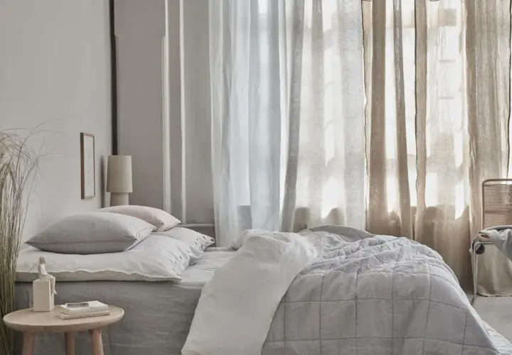 Schlafzimmer mit Bett, Kissen und Vorhängen. Kreative Gardinen Ideen für ein gemütliches Ambiente.