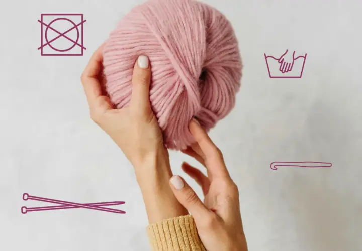 Hände halten rosafarbene Wolle. Symbole zeigen Handwäsche, kein Trocknen und Stricknadeln/Häkelnadel.