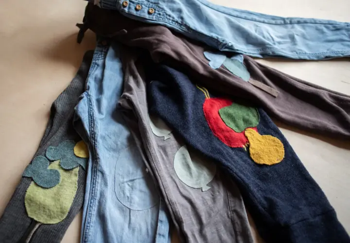 Bunte Flicken auf Kinderhosen. Ein **Knie** mit einem roten Apfel, daneben ein **Knie** mit Ballons. Liebevoll gestaltete **Hosen flicken**.