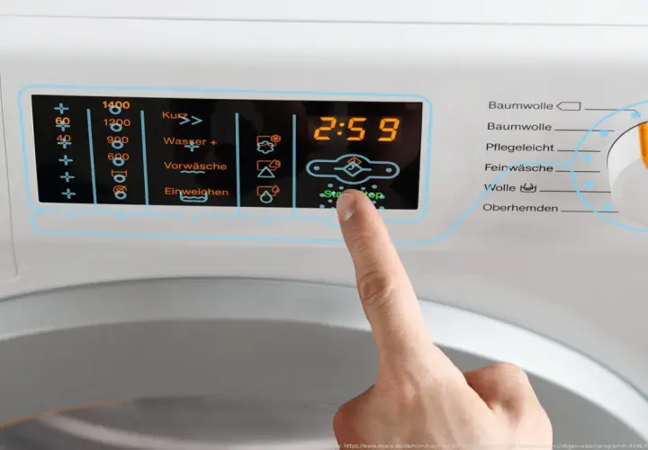 Finger drückt auf Start/Stop an Waschmaschine. Display zeigt 2:59. Wähle das richtige Programm für Wolle, achte auf die richtige Temperatur.