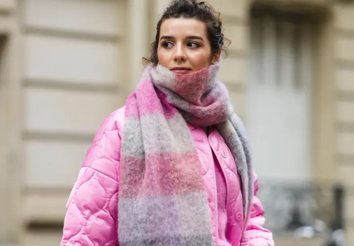 Frau mit pinker Jacke und gestreiftem Schal, inspiriert, einen Schal selber machen.
