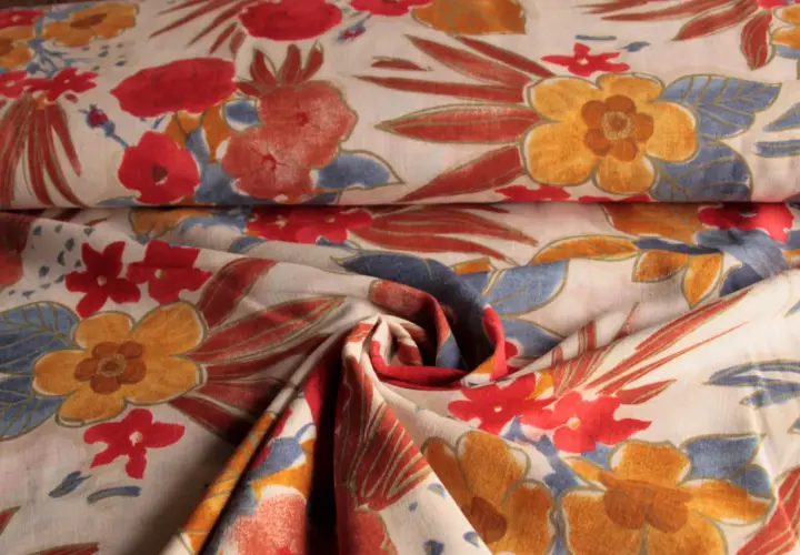 Stoff mit Blumenmuster, leuchtend rote und gelbe Blüten, blaue Blätter. Viskose gemische Stoffe für Sommerkleider.