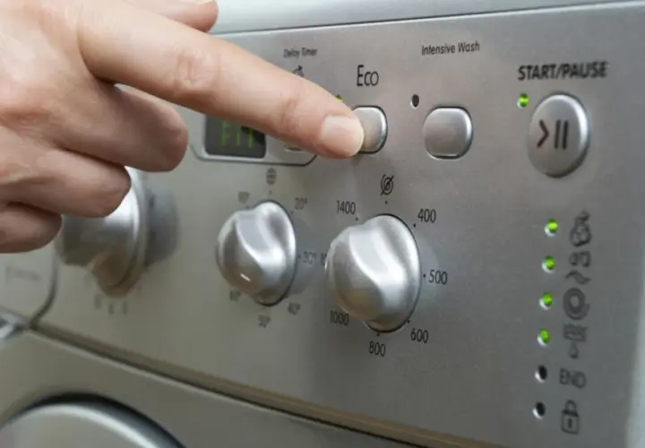Finger drückt "Eco"-Taste. Frage: wie lange dauert waschmaschine 60 grad? Das Display zeigt "FIT".