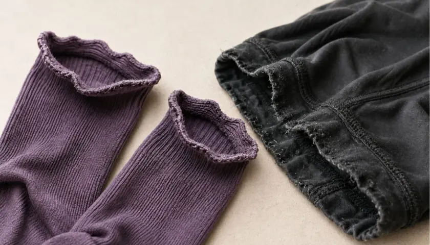 Lila Socken mit Rüschenrand und dunkle Hose. Elasthan Nachteile: Der Stoff kann ausleiern und die Nähte fransen.