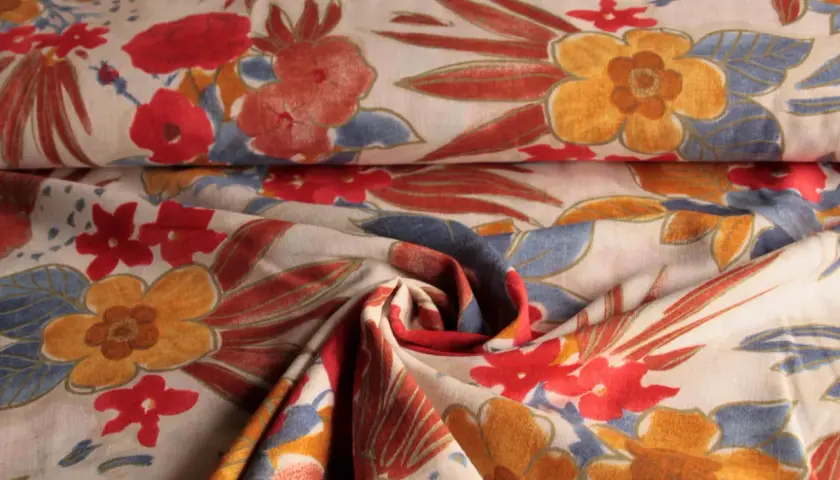 Stoff mit Blumenmuster, leuchtend rote und gelbe Blüten, blaue Blätter. Viskose gemische Stoffe für Sommerkleider.