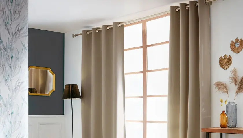 Ein Vorhang wird an einer Stange über einem Fenster angebracht. Daneben ein Spiegel und eine Lampe.