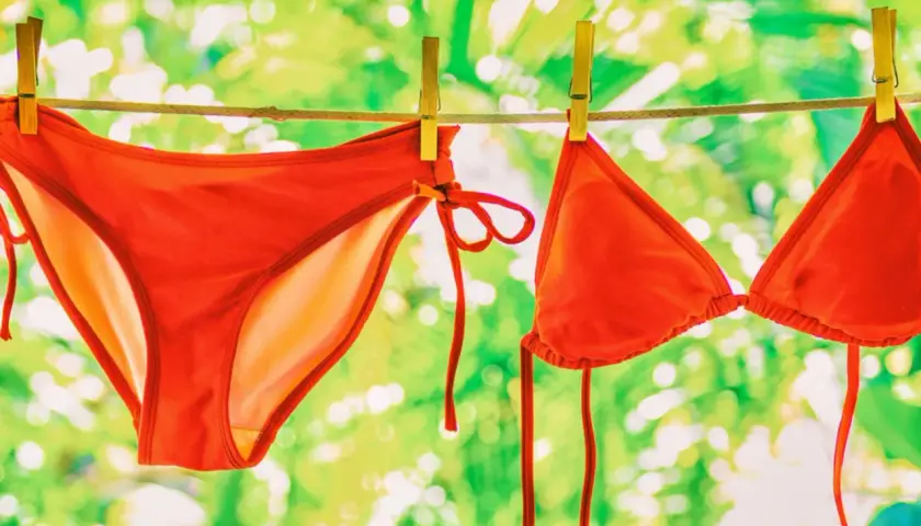 Roter Bikini trocknet an der Leine. Der Bikini waschen grad ist eine Vorfreude auf den Sommer.