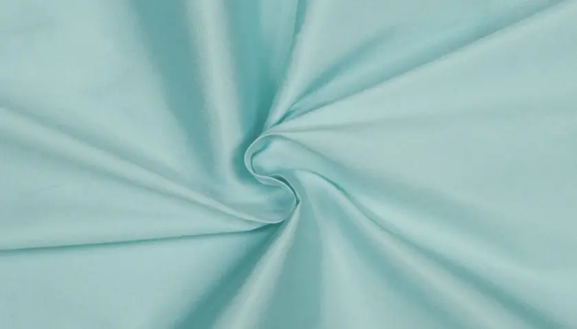 Türkis schimmerndes Gewebe, das an Kunstseide erinnert. Die Chemiefaser fällt weich und glatt.