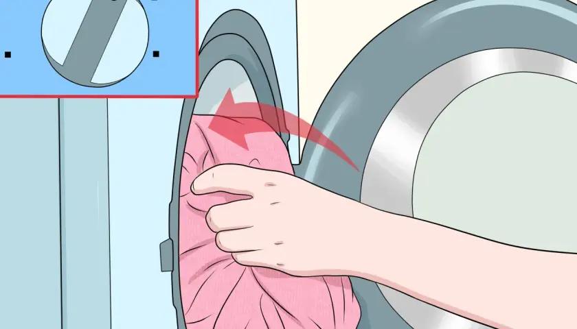 Hand lädt ein rosa Kleid in die Waschmaschine. Das Programm "Sanft" ist eingestellt, um zu verhindern, dass die Viskose eingelaufen ist.