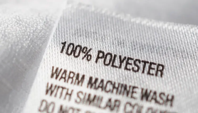 Etikett zeigt: 100% Polyester. Maschinenwäsche warm mit ähnlichen Farben. Nicht bleichen.