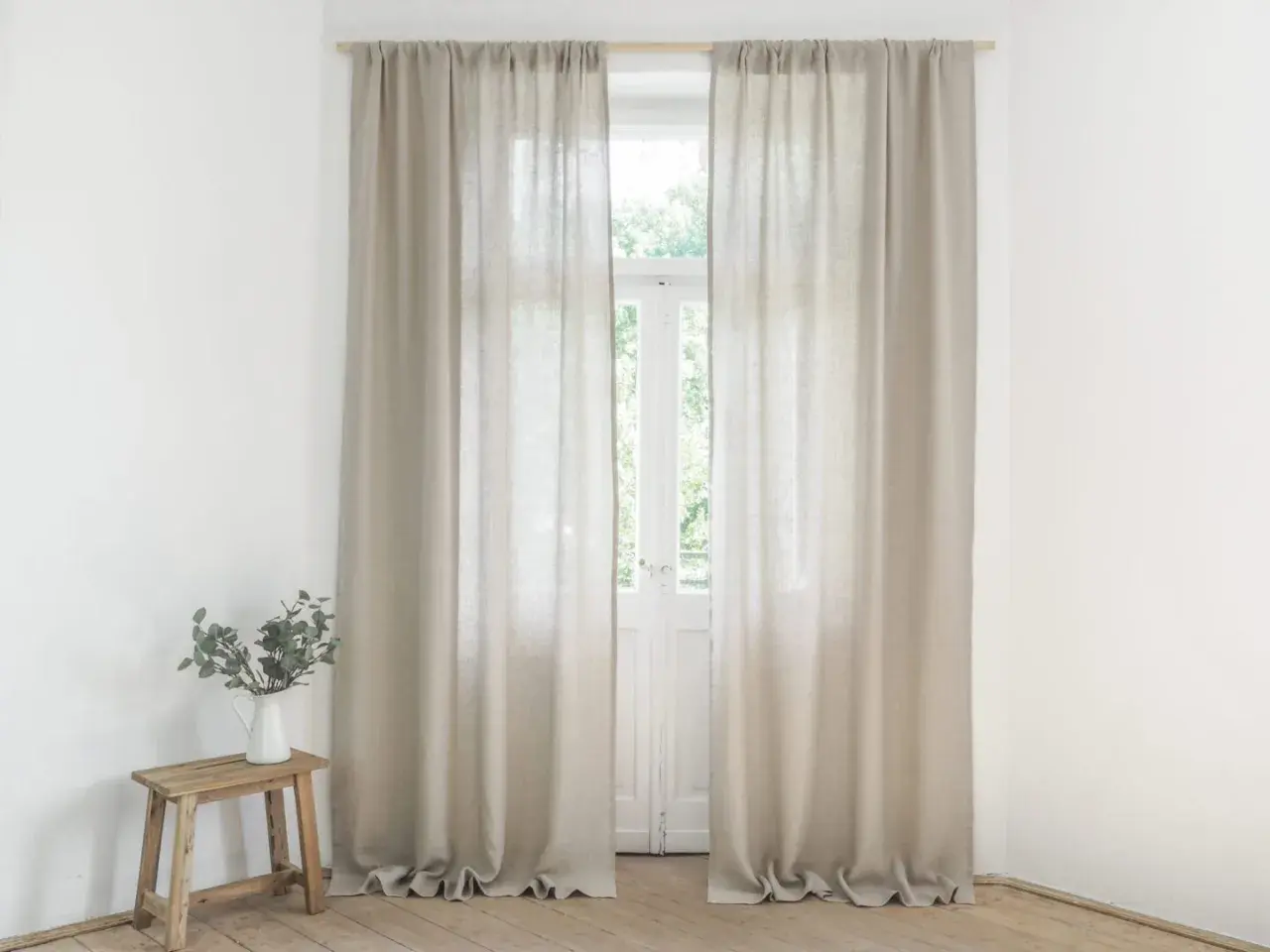 Helle Leinen Gardinen hängen vor einem Fenster. Sie sind frisch gewaschen und duften nach Sommer.