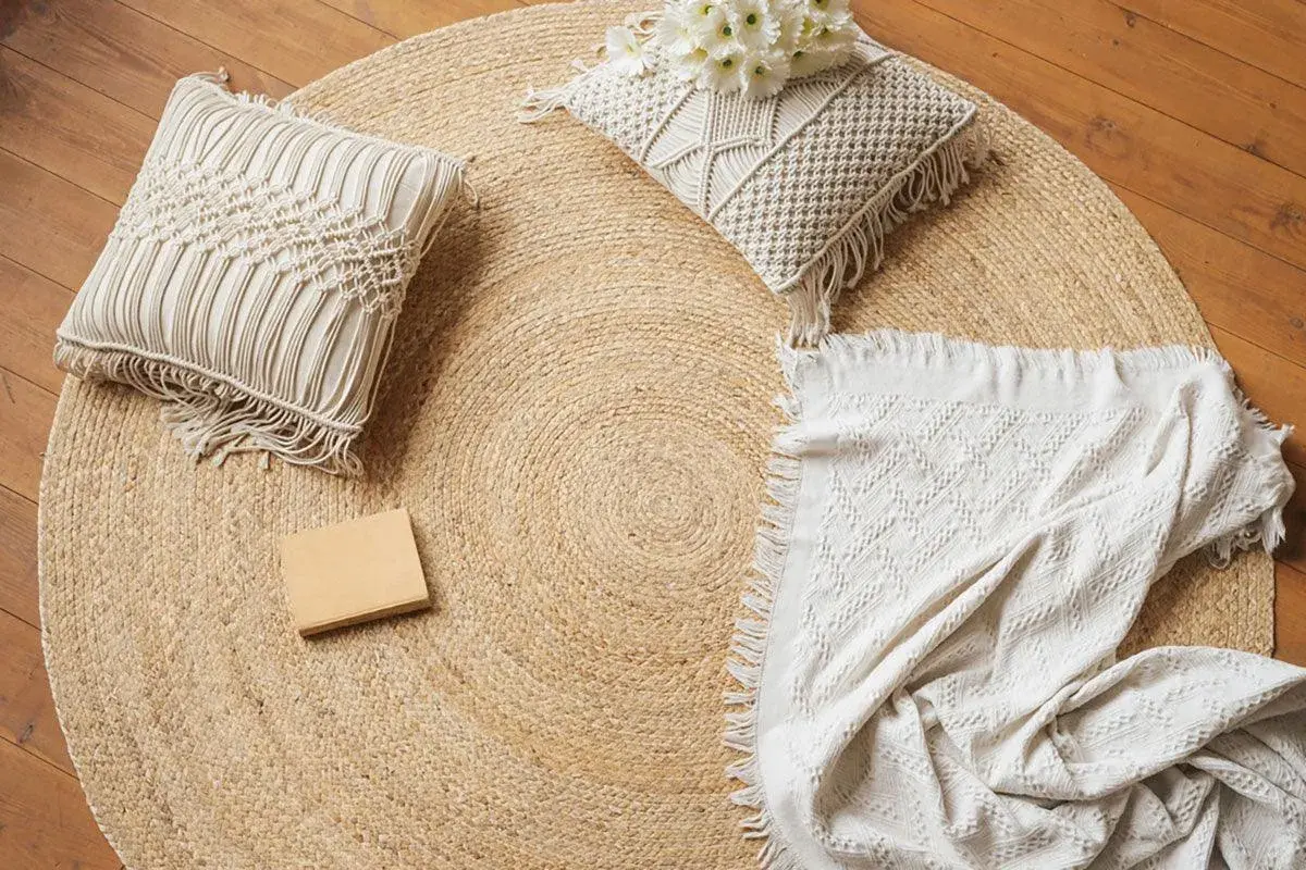 Runder Jute-Teppich mit Kissen und Decke. Jute ist ein Naturmaterial, das für seine Strapazierfähigkeit und seinen rustikalen Charme bekannt ist.