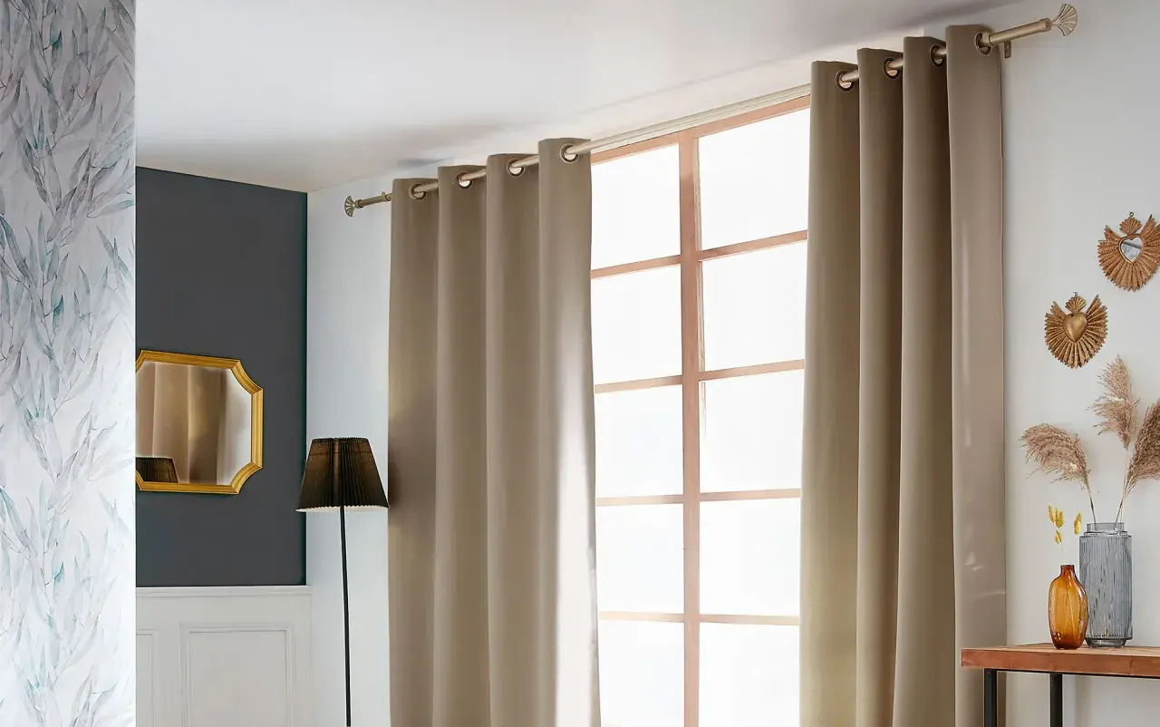 Ein Vorhang wird an einer Stange über einem Fenster angebracht. Daneben ein Spiegel und eine Lampe.