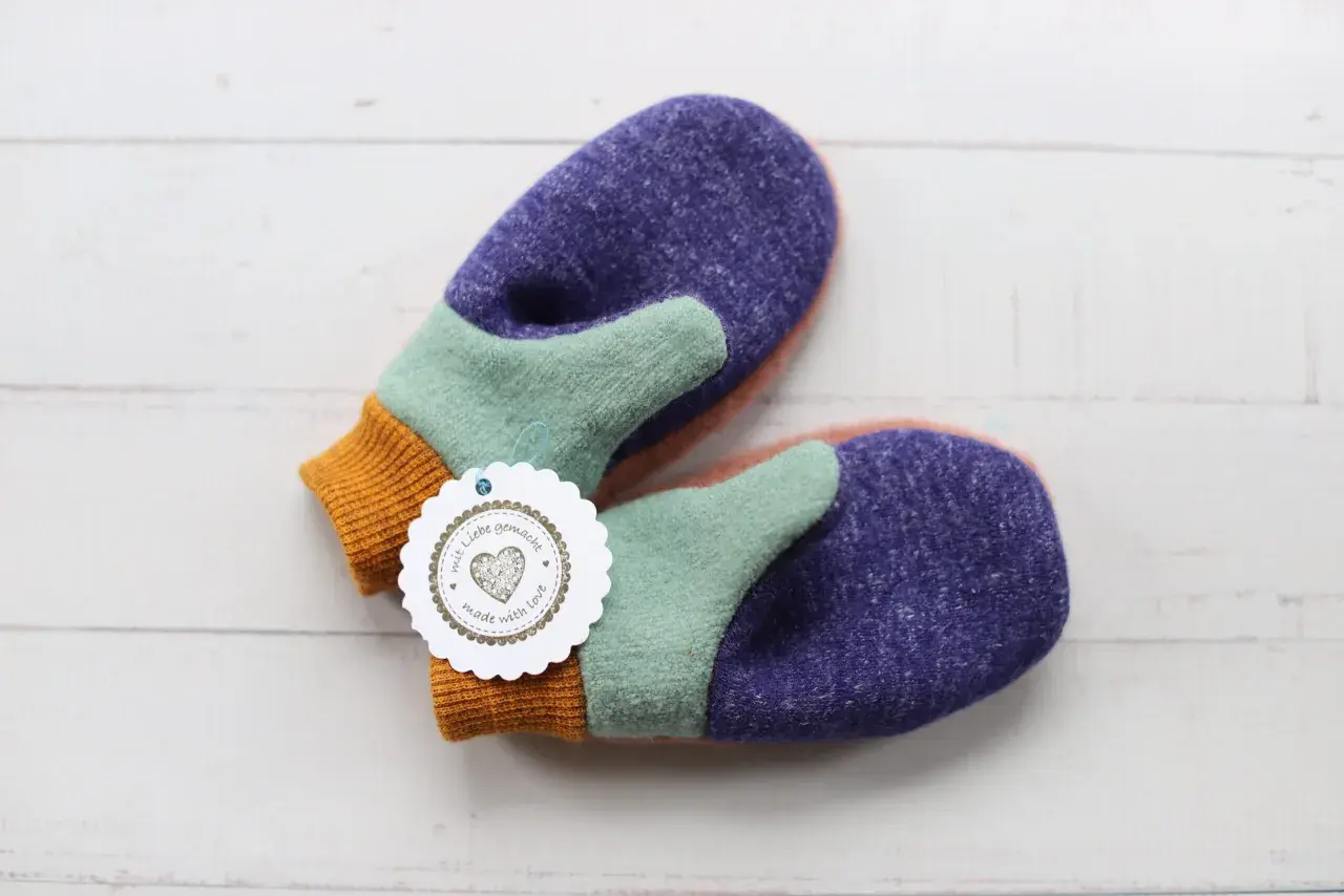 Bunte Fäustlinge mit einem "mit Liebe gemacht"-Anhänger. Ideal für DIY-Projekte, hier gibt es handschuhe schnittmuster kostenlos.