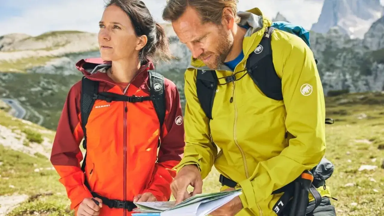 Wanderer studieren die Karte, ihre funktionsjacke waschen ist wichtig f&uuml;r die n&auml;chste Tour.