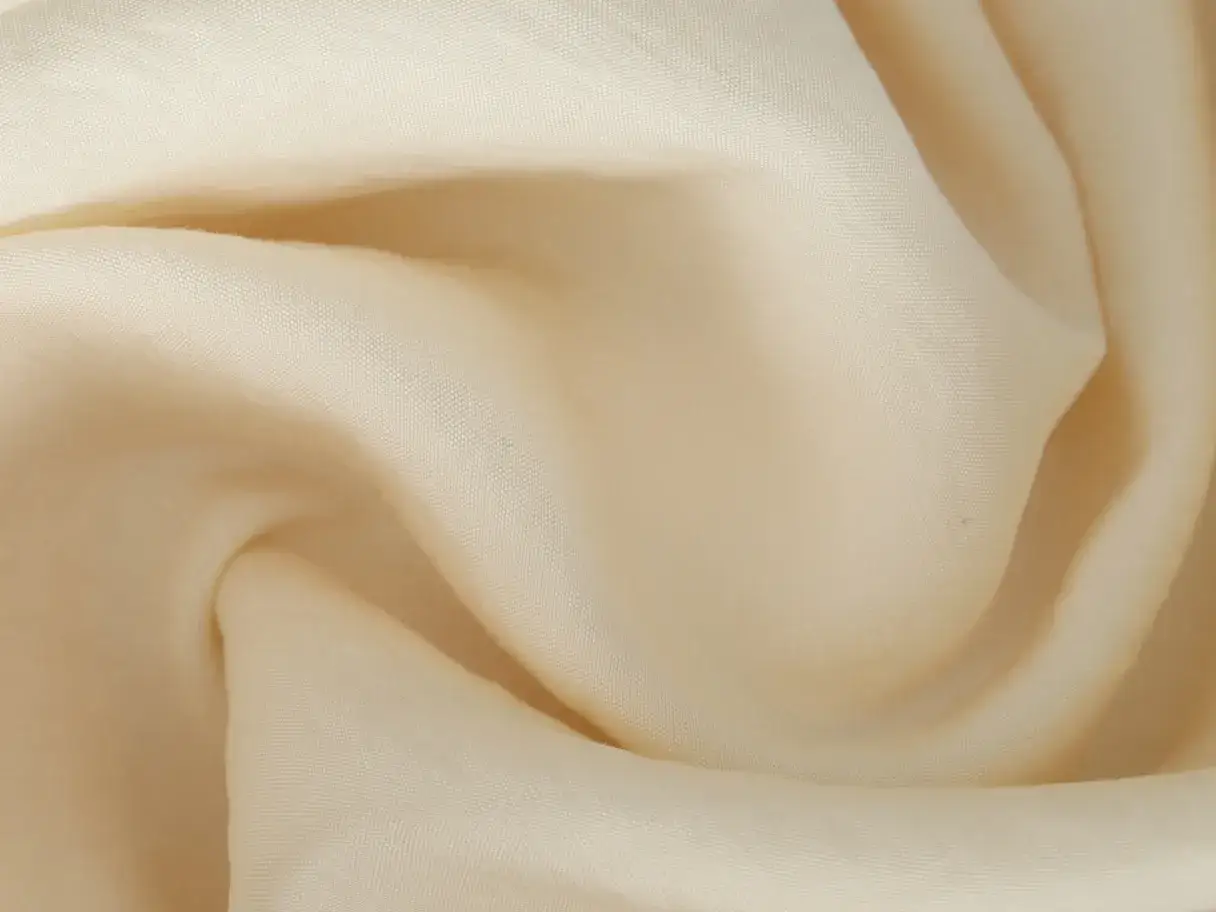 Cremefarbene Viskose Polyester Mischung, die sich weich anfühlt. Ideal zum Waschen und Pflegen.