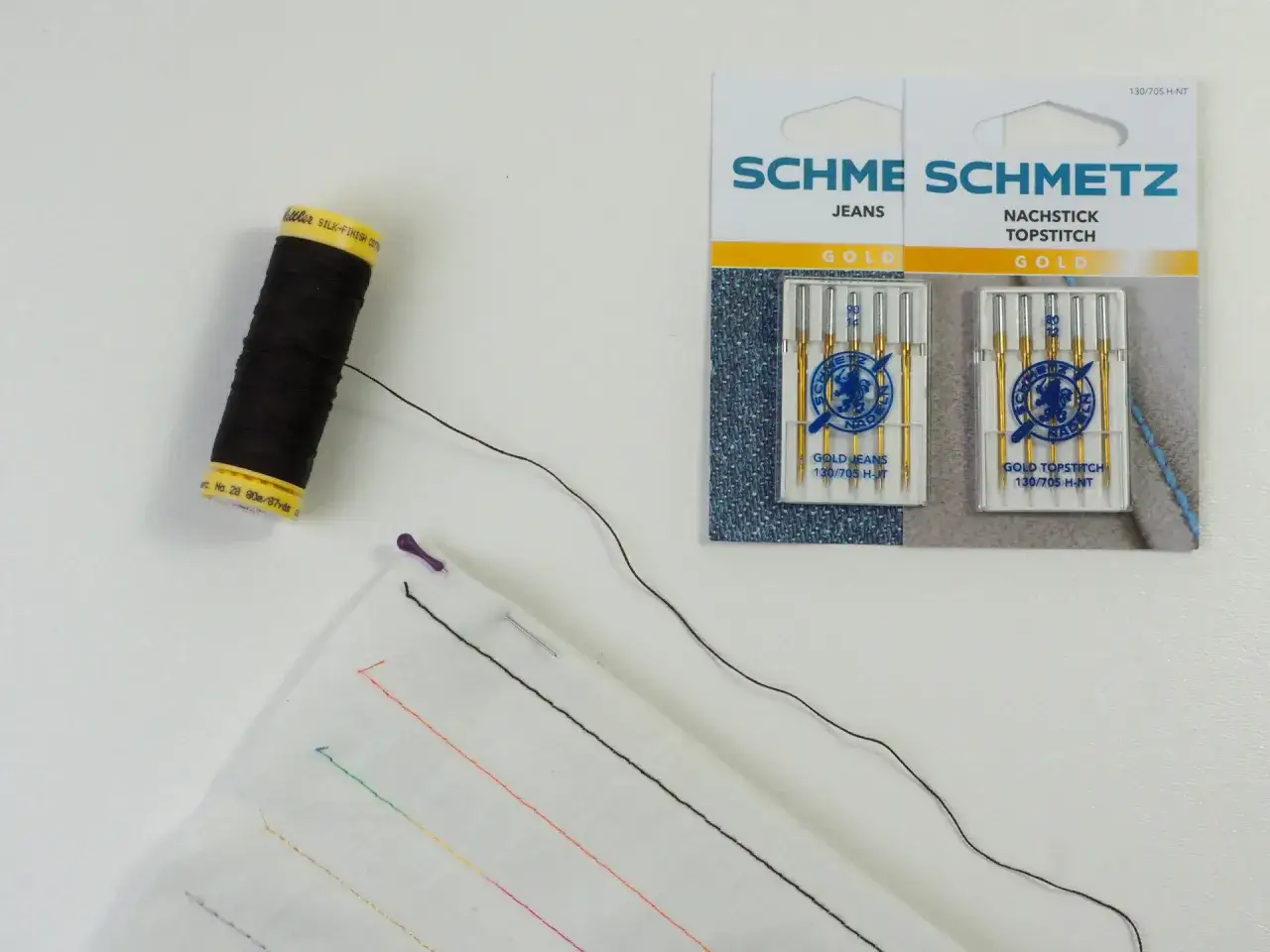 Schwarzer faden zum reparieren von kleidung, Nadeln und Stoff mit bunten Nähten.