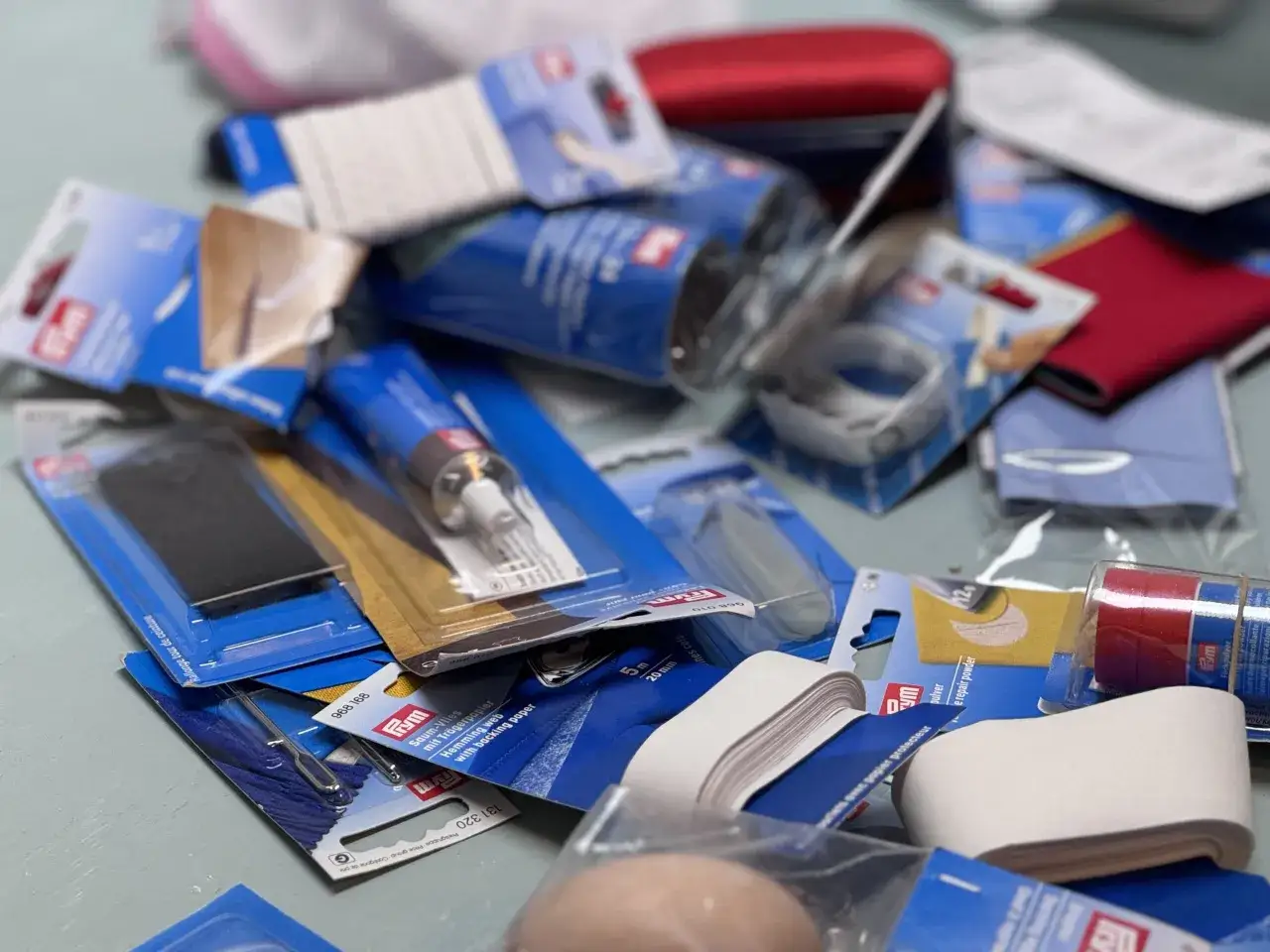 Nähzubehör wie Saumband und Flickpulver, um Kleidung zu reparieren und Pilling vermeiden.
