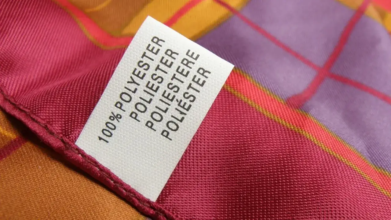 Etikett auf buntem Stoff: 100% Polyester. Das Material eignet sich gut zum Polyester färben in leuchtenden Farben.