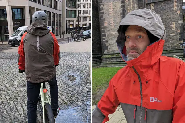 Mann mit Helm auf Fahrrad, trägt eine zweifarbige Funktionsjacke. Nahaufnahme des Mannes in der Jacke mit Kapuze.